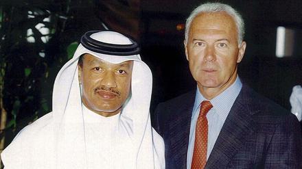 Franz Beckenbauer, damals Chef der DFB-Bewerbungskommission für die Fußball-WM 2006, (r), und Mohamed bin Hammam, Mitglied Katars im FIFA-Exekutivkomitee, posieren am 25.07.2000 in Doha (Katar) vor der Kamera. 