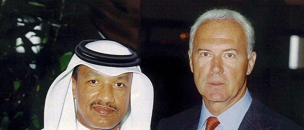 Franz Beckenbauer, damals Chef der DFB-Bewerbungskommission für die Fußball-WM 2006, (r), und Mohamed bin Hammam, Mitglied Katars im FIFA-Exekutivkomitee, posieren am 25.07.2000 in Doha (Katar) vor der Kamera. 