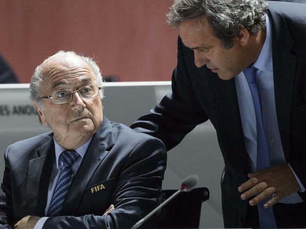 FILES - A picture taken on May 29, 2015 shows FIFA President Sepp Blatter (L) listening to UEFA President Michel Platini during the 65th FIFA Congress in Zurich. Embattled FIFA chief Joseph Blatter is suspected of "disloyal payment" to UEFA head Michel Platini, who had hoped to succeed him, the office of Switzerland's attorney general said on September 25, 2015. AFP PHOTO / FABRICE COFFRINI