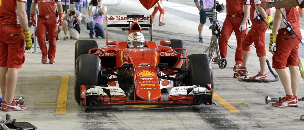 Sebastian Vettel mit seinem Ferrari in der Box.