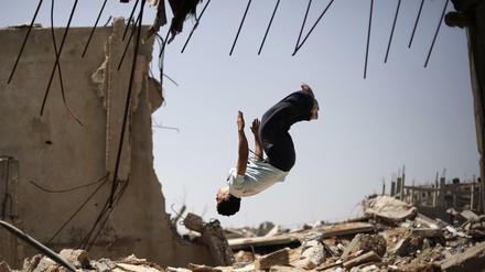 Foto: Afp/ Mohammed Abed Ein junger Palestinenser übt Freerunning in den Ruinen eines Gebäudes
