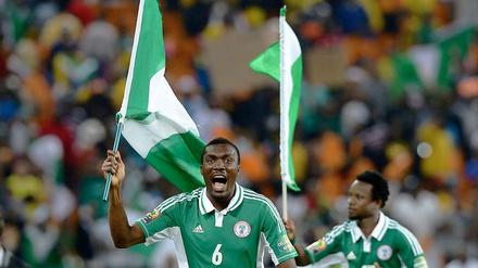 Jubel mit Fahne. Nigerias Verteidiger Azubuike Egwuekwe feiert den Triumph.