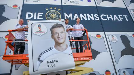 Helfer hängen das Bild von Marco Reus während der DFB-Pressekonferenz an die Außenwand des Fußballmuseums.