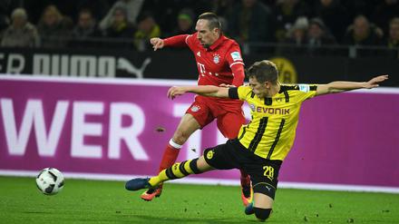 Im Hinspiel fügten die Dortmunder um Matthias Ginter den Bayern (l. Franck Ribery) die erste Saisonniederlage zu.