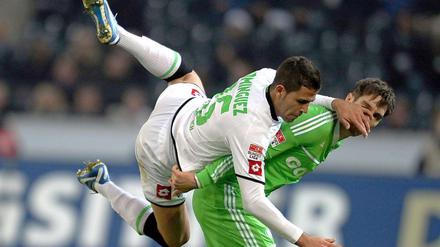 Der Gladbacher Dominguez (l.) und der Wolfsburger Srdjan Lakic versuchen den Ball zu spielen.
