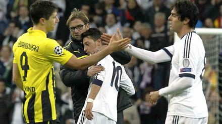 Trost für den "Schalker": BVB-Trainer Jürgen Klopp nimmt sich Mesut Özil zur Brust (hinten), während Robert Lewandowski mit Real Madrids Kaká (r.) abklatscht.