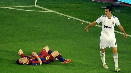 Klassisch: Barcas Messi am Boden, und keiner will's gewesen sein. Auch nicht der Madrider Arbeloa.
