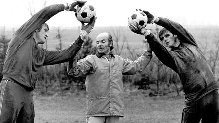 Strecken für den Trainer. Die Bayern-Torhüter Sepp Maier (li.) und Hugo Robl (re.) mit Dettmar Cramer im Jahr 1975.