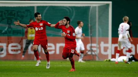 Leverkusens Hakan Calhanoglu (re.) feiert mit Emir Spahic den Führungstreffer.