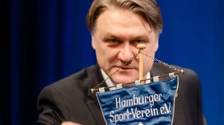 Vorstandschef Dietmar Beiersdorfer greift nach einem HSV Wimpel. 