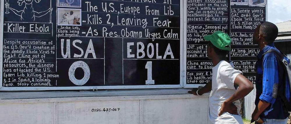 1:0 für Ebola: In Monrovia informieren sich die Leute an einer Nachrichtentafel.