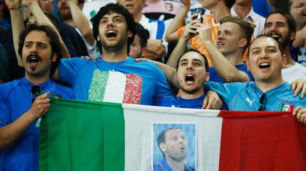 Italienische Fans singen mit Stolz und Emotionen Italiens Hymne als perfekte Einstimmung auf das Spiel. 