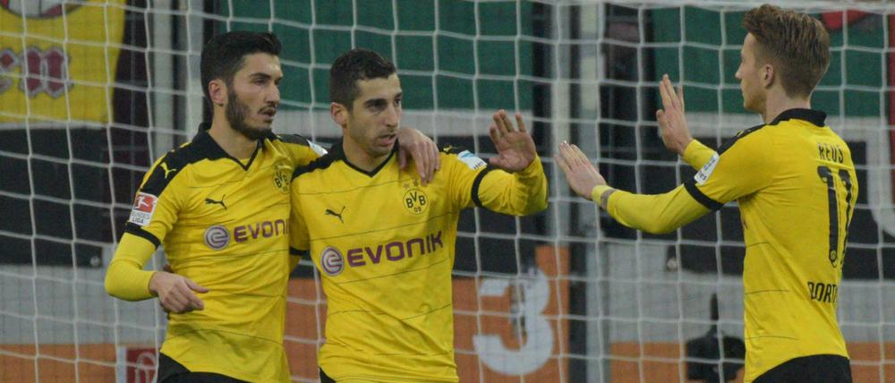 Die Dortmunder Nuri Sahin (l) und Marco Reus (re.) gratulieren Henrikh Mkhitaryan nach dessen Tor zum 1:1-Ausgleich.