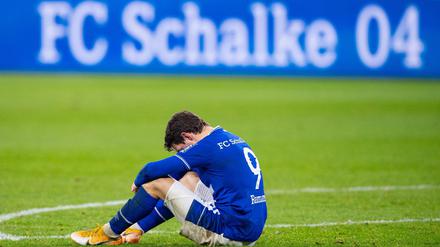 Schalkes Benito Raman sitzt nach dem Abpfiff auf dem Rasen. 