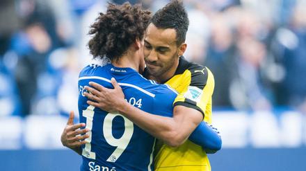 Schalkes Leroy Sané (l) und Pierre-Emerick Aubameyang von Dortmund umarmen sich nach dem Spiel. 