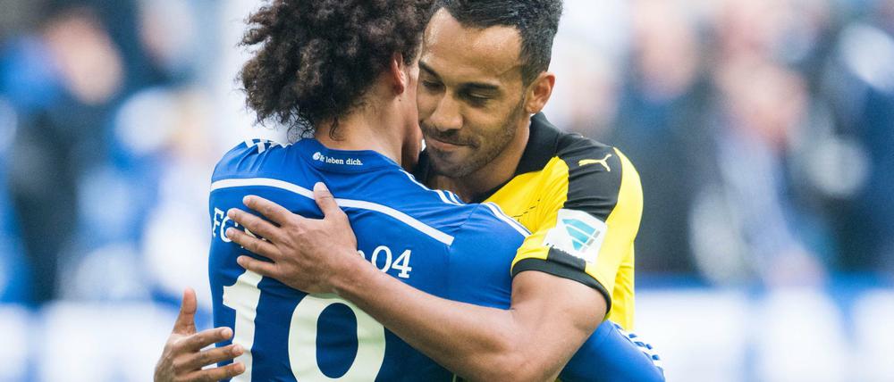 Schalkes Leroy Sané (l) und Pierre-Emerick Aubameyang von Dortmund umarmen sich nach dem Spiel. 