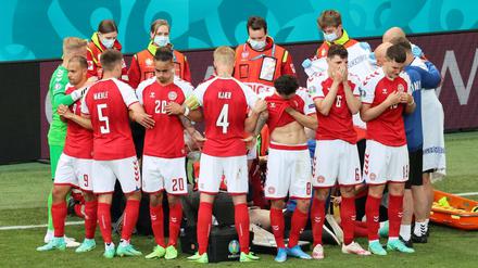 Dänische Spieler reagieren, als Christian Eriksen nach einem Zusammenbruch während des Spiels gegen Finnland medizinisch versorgt wird.