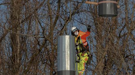 Der Mast kommt aus der Luft. Ein Arbeiter montiert die Teile eines Flutlichtmasts im Poststadion an der Lehrter Straße zusammen, geliefert vom Hubschrauber.