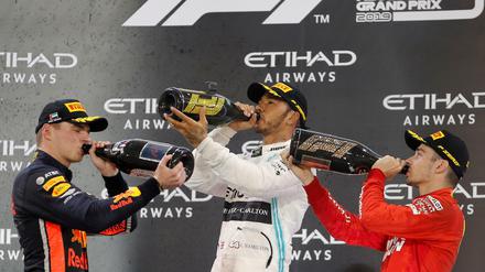 Prost! Lewis Hamilton (Mitte), Max Verstappen (links) und Charles Leclerc (rechts) feiern eine gelungene Formel-1-Saison. 