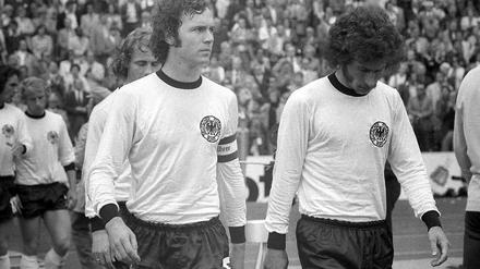 Kaiser Franz Beckenbauer (im Bild mit Paul Breitner). 1974 waren die Haare lang, heute gibt es Geld von Gazprom. 