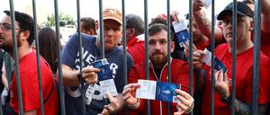 Fans des FC Liverpool warten vor dem Stadion und präsentieren ihre Karten.