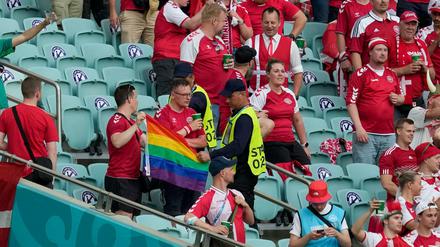 Zwei Ordner nehmen beim Spiel zwischen Dänemark und Tschechien in Baku zwei Dänemark Fans eine Regenbogen-Fahne ab.