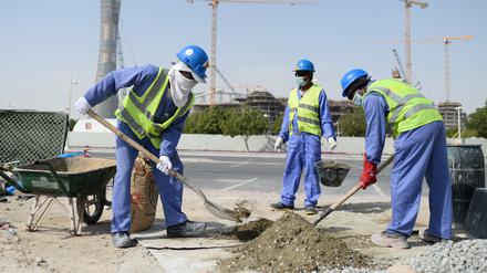 Bauarbeiter aus Sri Lanka arbeiten auf einer Baustelle vor dem Hotel „The Torch“ und dem Khalifa International Stadium in Doha.