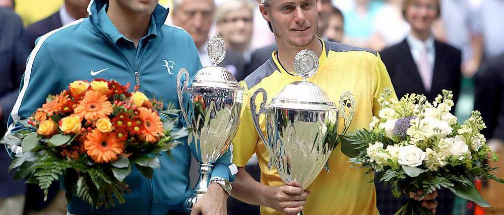 Lleyton Hewitt (r.) mit dem großen Pokal. Roger Federer nimmt die Finalniederlage von Halle aber scheinbar gelassen.
