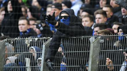 Ein HSV-Fan gestikuliert nach dem Spiel in Richtung von Polizeibeamten.