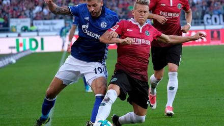Hannovers Matthias Ostrzolek (r) und Schalkes Guido Burgstaller kämpfen um den Ball.