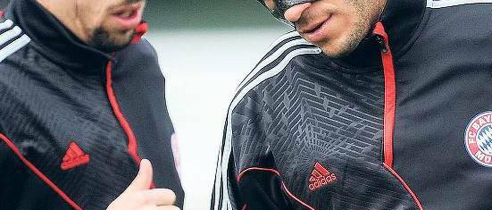 Angeschlagen ins Spiel. Martin Demichelis (r.) demonstriert mit seiner Gesichtsmaske den Zustand des FC Bayern. 