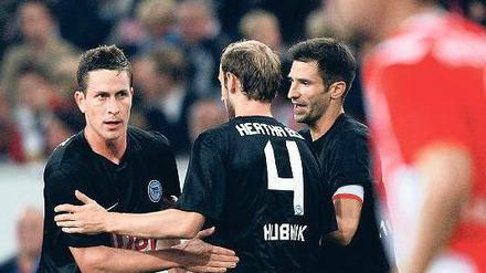 Glückwünsche im Vorbeigehen. Roman Hubnik (Mitte) und Andre Mijatovic herzen kurz Rob Friend (links), der Hertha in Düsseldorf in Führung schoss. Foto: dpa