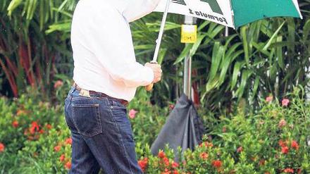 Durch den Monsun. In Asien braucht Bernie Ecclestone öfter mal den Schirm.