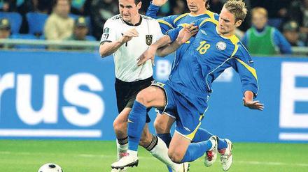 Im Mittelpunkt. Miroslav Klose (links) setzte sich erst gegen den Kasachen Maxim Asowski durch, schoss später sein 58. Länderspieltor und musste den Platz in Astana dann verletzt verlassen. Foto: dpa