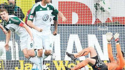 Torwart am Boden, Ball im Netz. Edin Dzeko (links) bejubelt Wolfsburgs Führungstreffer gegen Stuttgart. Foto: dpa