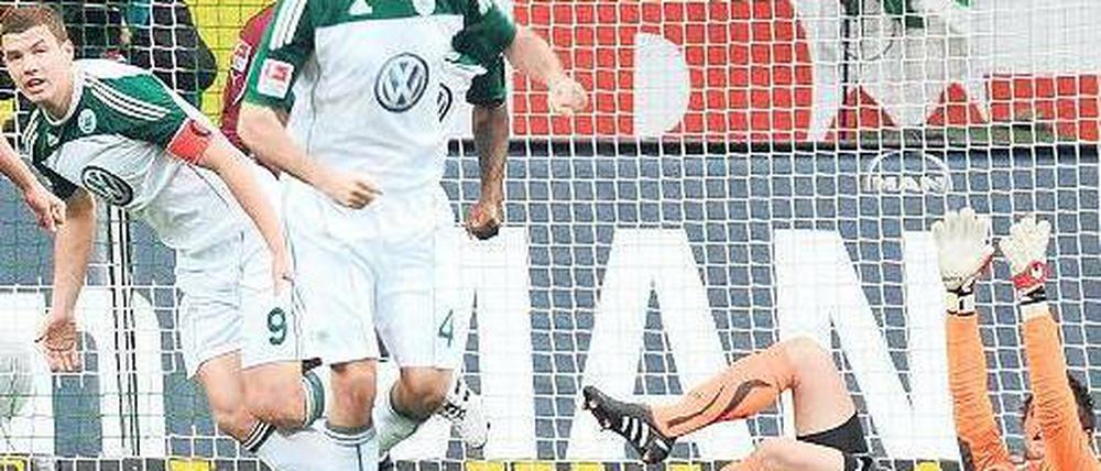 Torwart am Boden, Ball im Netz. Edin Dzeko (links) bejubelt Wolfsburgs Führungstreffer gegen Stuttgart. Foto: dpa