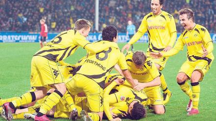 Gelbe Haufenbildung. Die Dortmunder Spieler treffen anlässlich des Freiburger Eigentores zum 2:1 spontan und gut gelaunt zusammen. Foto: dpa