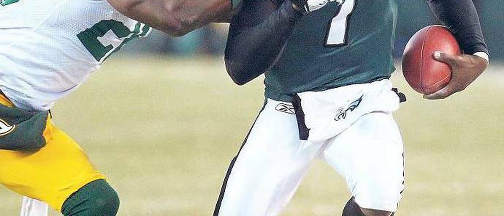 Angriff von der Seite. Eagles-Quarterback Michael Vick versucht sich der Attacke der Green Bay Packers zu entziehen. Foto: Reuters