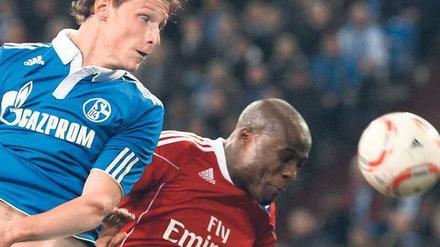 Nicht auf Augenhöhe. Der Schalker Benedikt Höwedes (l.) beim Kopfballduell mit dem Hamburger Guy Demel. Foto: dpa
