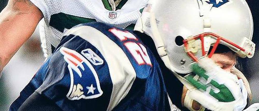 Leaving on a Jet Plane. Patriots-Quarterback Tom Brady wird von Jets-Cornerback Drew Coleman gestoppt. Foto: dpa