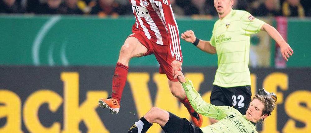 Hürde übersprungen. Bayern Münchens Thomas Müller (l.) lässt sich von Aachens Tobias Feisthammel nicht stoppen. Foto: dpa