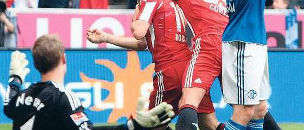 Ratloser Top-Mann. Schalkes Torhüter Manuel Neuer ist am Boden, Arjen Robben (Mitte) und Mario Gomez feiern. Foto: dpa