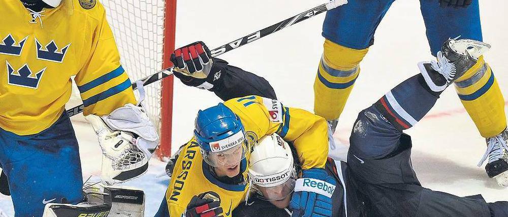 Eiskalter Schwitzkasten. Schweden spielt eine starke WM, hier ringt Carl Gunnarsson den Amerikaner Yan Stastny nieder. Foto: AFP