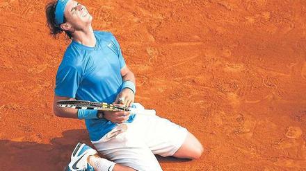 Genug gequält. Rafael Nadal ließ sich nach seinem Sieg über Roger Federer glücklich in die rote Asche von Paris sinken. Der Spanier hatte in den ersten Runden einige Probleme gehabt und selbst nicht an den erneuten Titelgewinn geglaubt. Foto: Reuters
