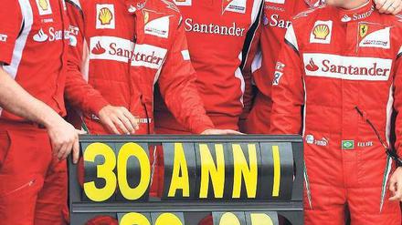 Im Zeichen der 30. Zum Geburtstag bekam Alonso (2. v. l.) eine Boxenparty – 30 WM- Punkte wären ihm lieber gewesen. Foto: AFP