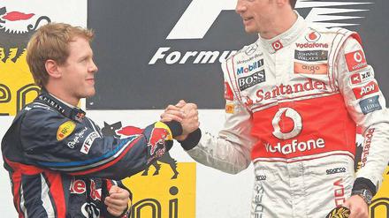 Sebastian Vettel (l.) gratuliert dem Briten Jenson Button zum Sieg. 