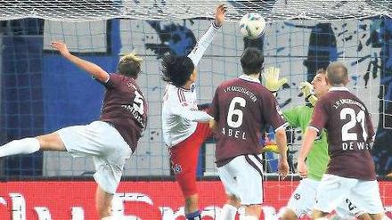 Drei Rote gegen einen Weißen. Paolo Guerrero kann sich dennoch durchsetzen und den Ausgleich für den Hamburger SV köpfen. Foto: dapd