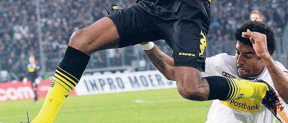 Luftnummer. Dortmunds Brasilianer Santana wird von Gladbachs Brasilianer Dante am großen Sprung gehindert. Foto: dapd