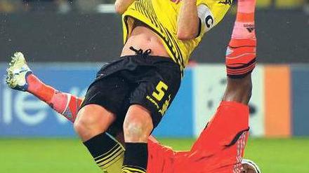 Schwerer Schlag. Dortmunds Kapitän Sebastian Kehl (l.) wird von Stéphane Mbias Fuß im Gesicht getroffen und muss ausgewechselt werden. Foto: AFP