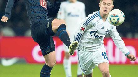 Augen zu und durch. Andreas Ottl (li.) und der Schalker Lewis Holtby. Foto: AFP